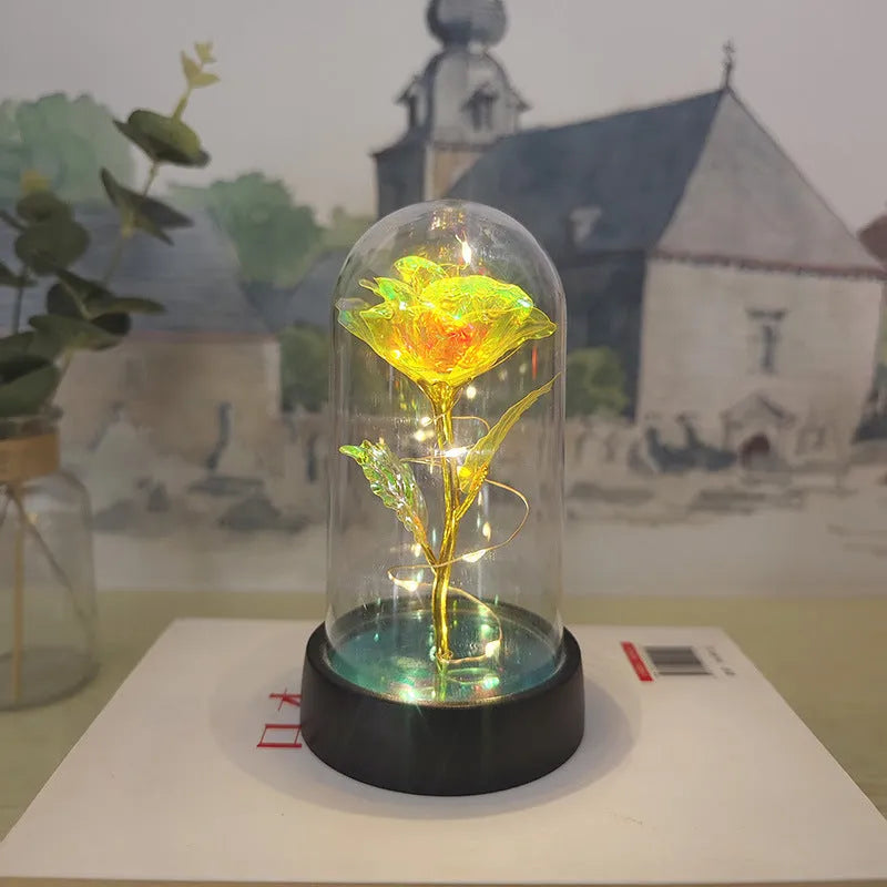 Small plastic decorative night lamp with coloured glass cover and black base on a table.