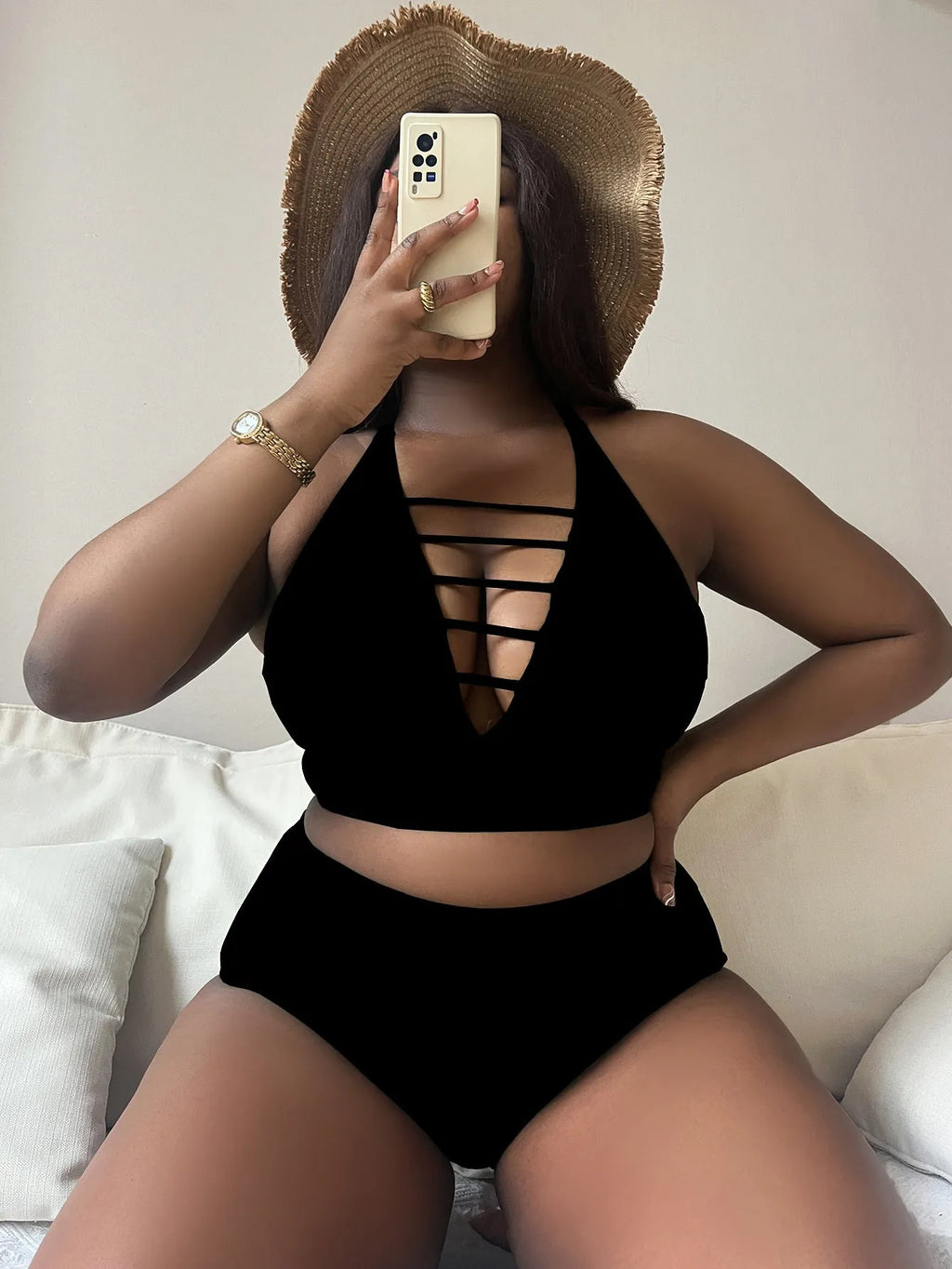 Plus size woman modelling a black halter bikini with adjustable cross straps and high-waisted briefs.