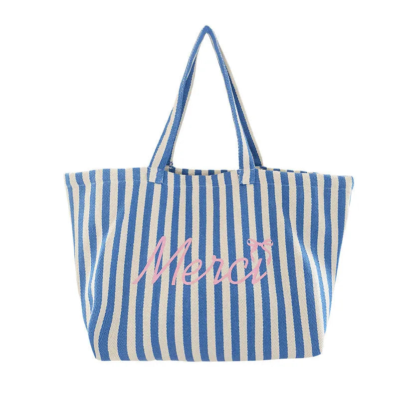 Blue striped letters printed on a pink, blue, and white striped cotton canvas bag for daily matching.
