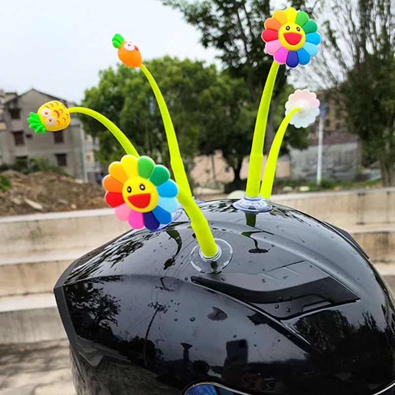 Yellow silicone sunflower helmet decoration with swinging stem and suction cup on a visor.