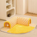 XL fan-shaped plush pet bed with a tunnel, in a plaid coffee colour, on a wooden floor.