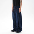 Dark blue washed distressed denim wide leg machete jeans laid flat, showing the wide leg cut and textured finish.