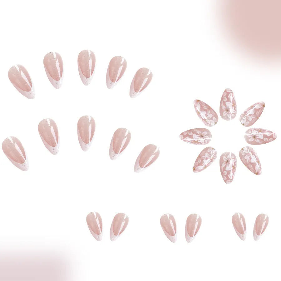 Short almond-shaped plastic false nails with glossy white French tips and pink glitter powder flower design.