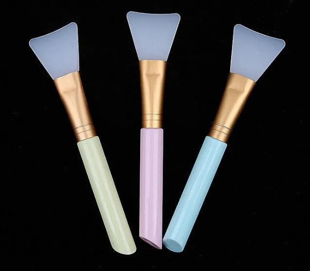 Fan makeup brush with nylon bristles and plastic handle, available in blue and pink colours