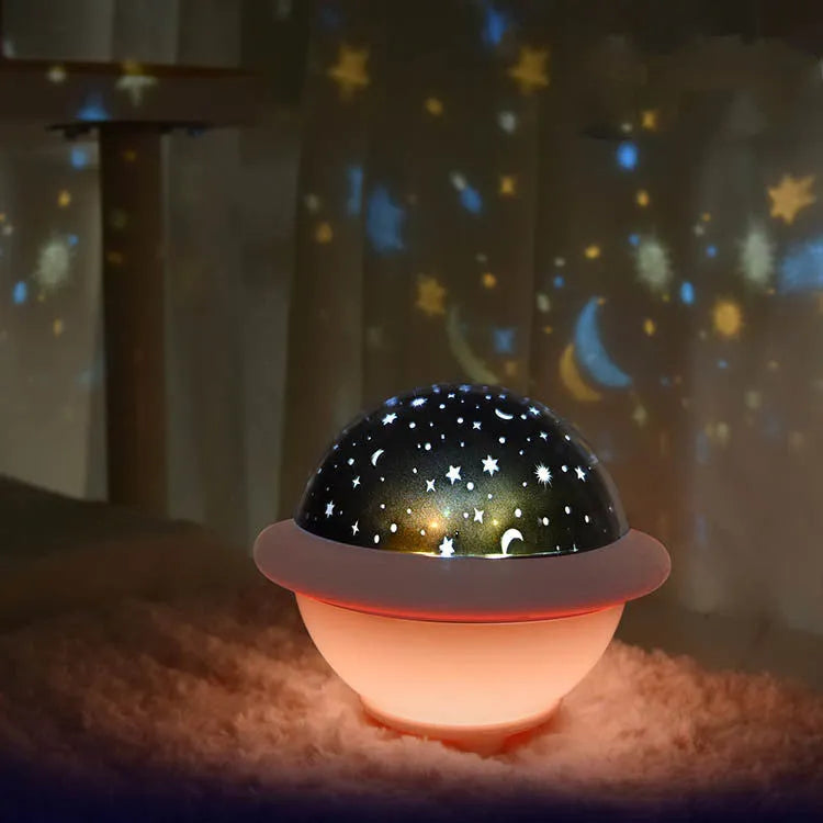 Green UFO-shaped plastic night light projecting a starry sky pattern on a wall.