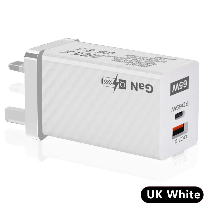 White 65W Gallium Nitride USB-C laptop charger with UK plug on a wooden desk