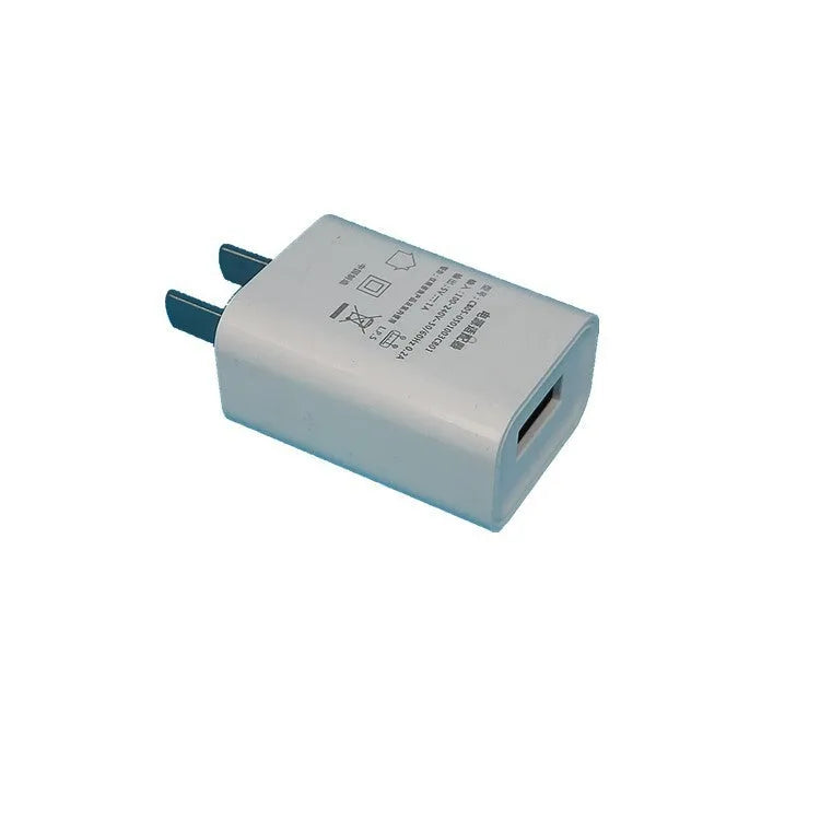 Thin white USB wall charger with CE and FCC marks on a plain background.