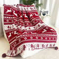 Personalised acrylic Christmas blanket with reindeer pattern draped over a grey sofa
