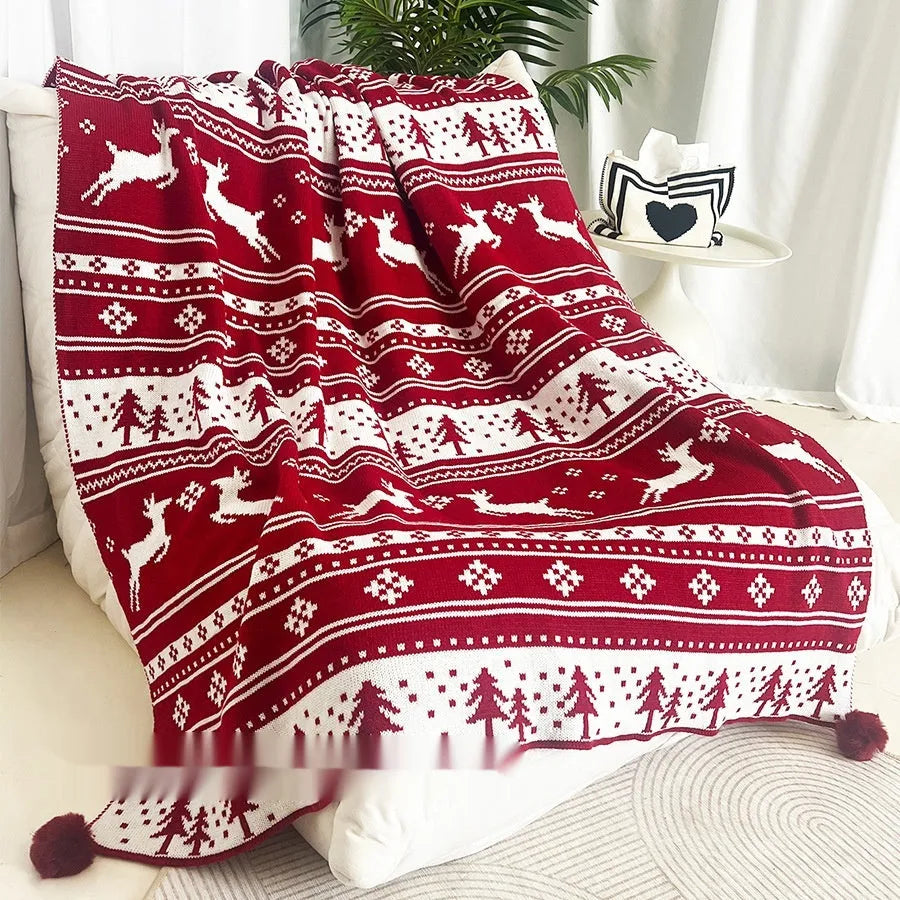 Personalised acrylic Christmas blanket with reindeer pattern draped over a grey sofa