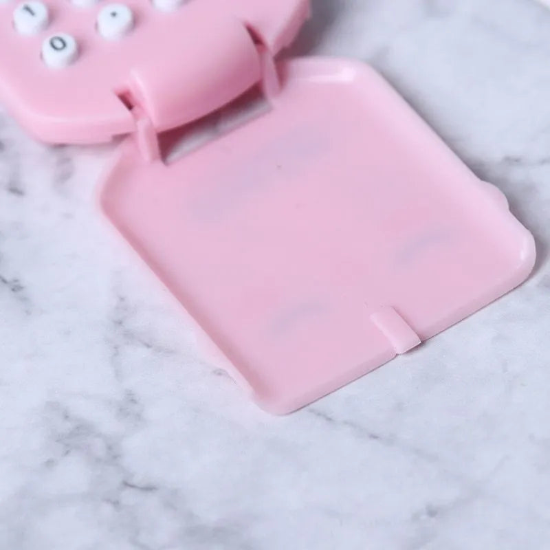 Cookie-shaped mini calculator with key ring in pink, blue, grey, or black, 6.4 x 3.6 x 11.2 cm plastic body