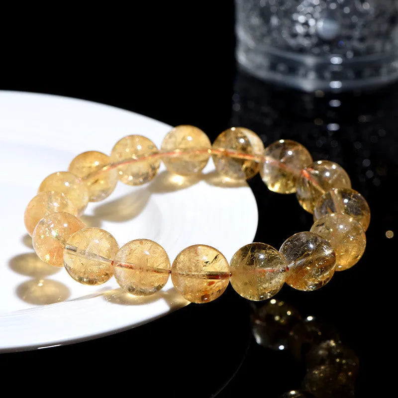 Natural yellow citrine gemstone bead bracelet on a wrist, showing geometric beads.