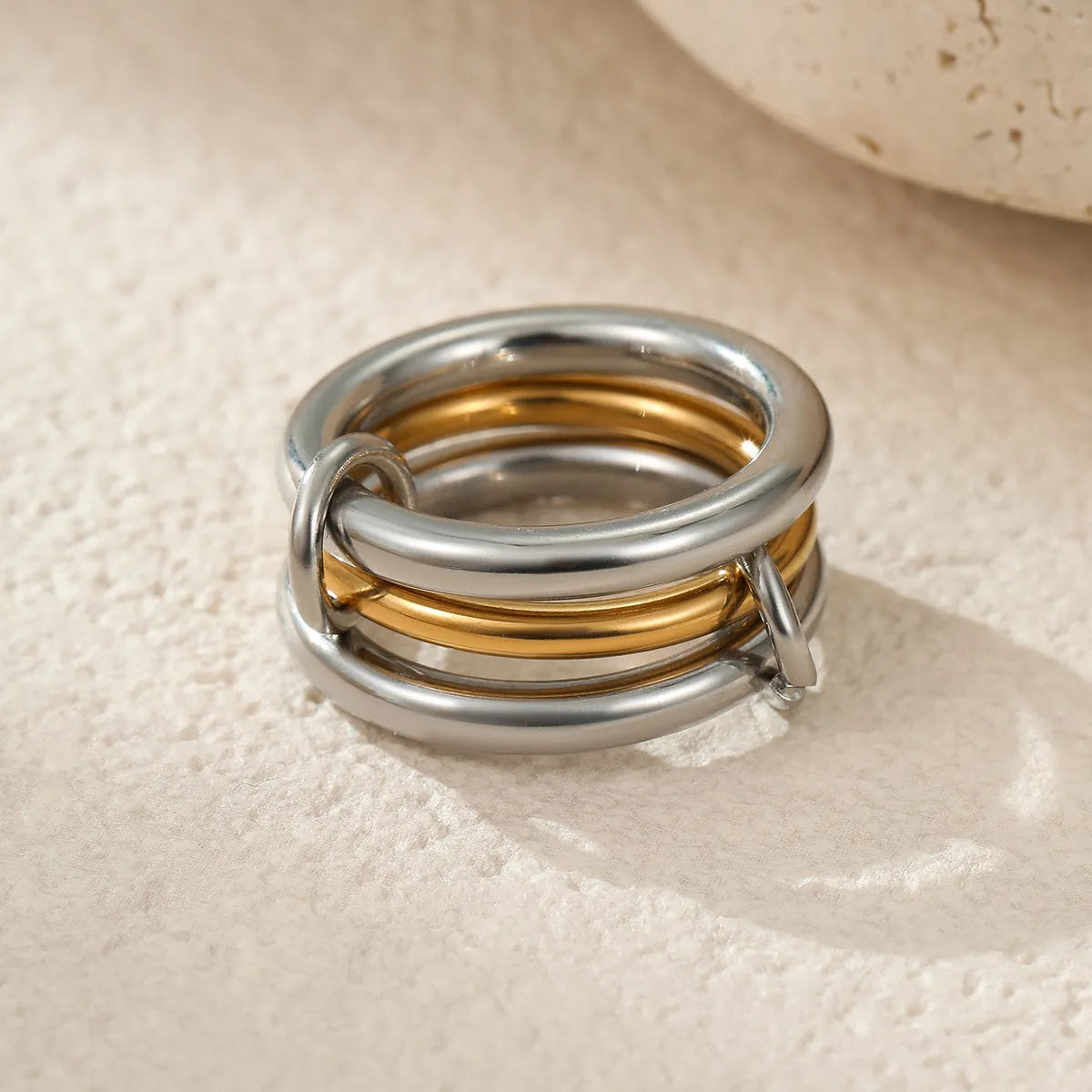 Stacked stainless steel rings with 18K gold plating in an exaggerated silhouette design.