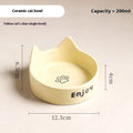 Porcelain cat bowl in a wooden anti-tip frame, showing cat's paw print design in pink.