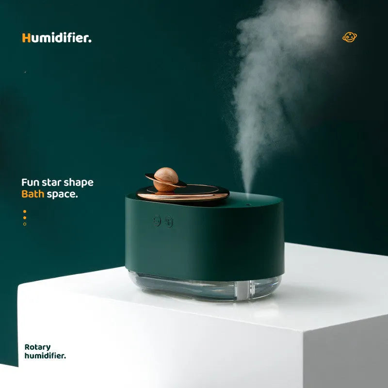 Green rotating planet humidifier with USB charging port and night light on white surface