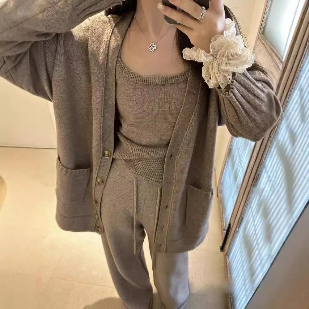 Women's light brown knit cardigan, vest, and loose trousers three-piece set laid flat.