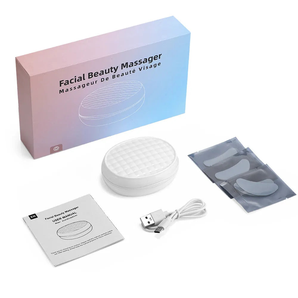 White wireless red light EMS eye and face massager device on a plain background.