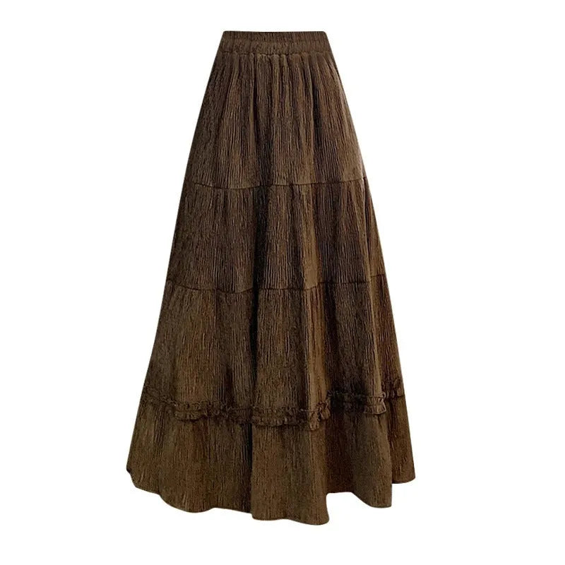 A woman wearing a beige corduroy A-line midi skirt with an elasticated waistband.