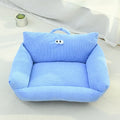Blue cartoon big eye pet sofa kennel bed for small dog on a wooden floor.