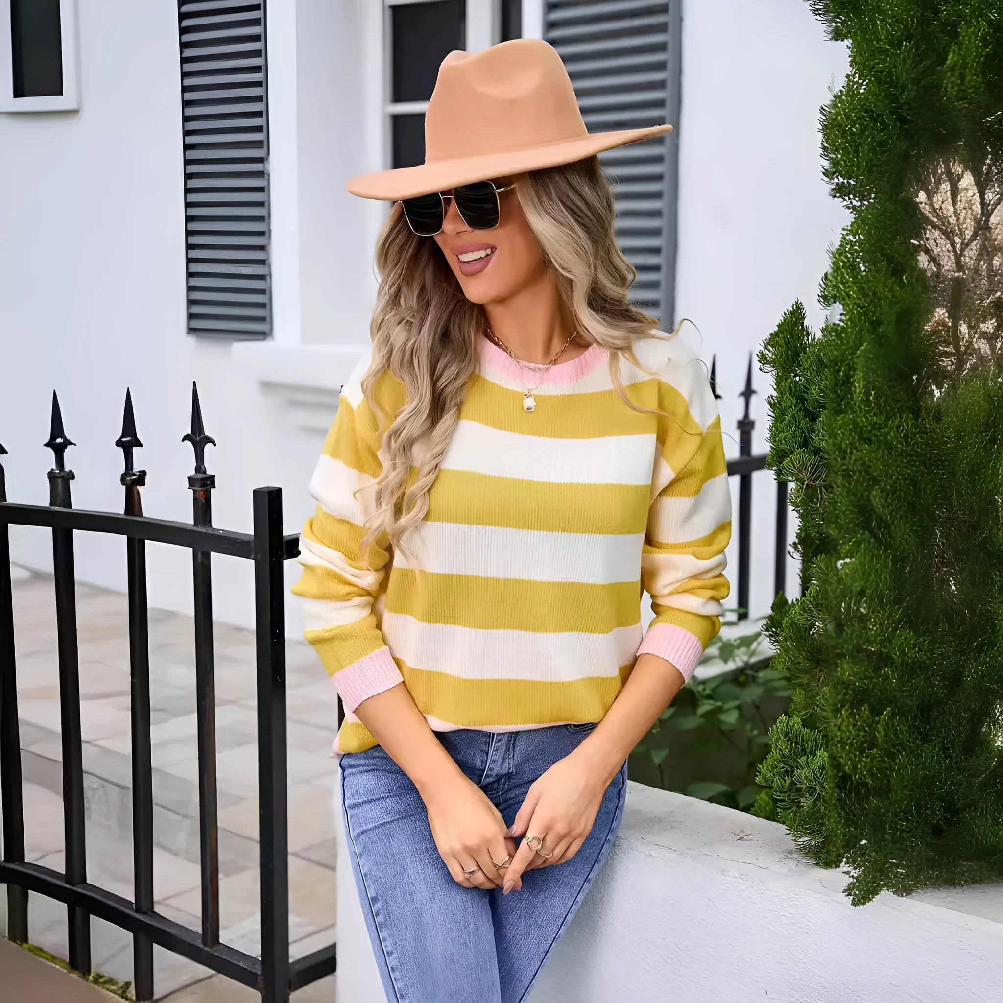 Women's loose blue acrylic sweater with long sleeves and a striped pattern on a hanger.