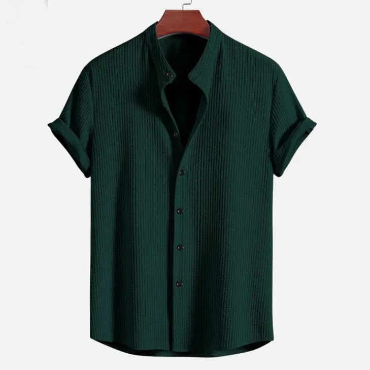 Men's loose fit short sleeve polyester shirt shown in a light blue colour on a hanger.
