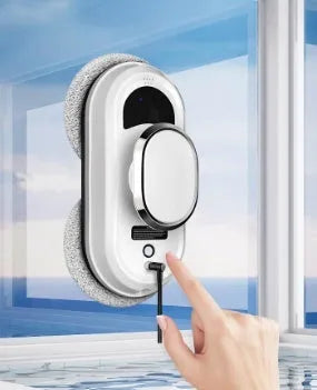 White full-automatic high altitude window cleaning machine with remote control on a windowsill.