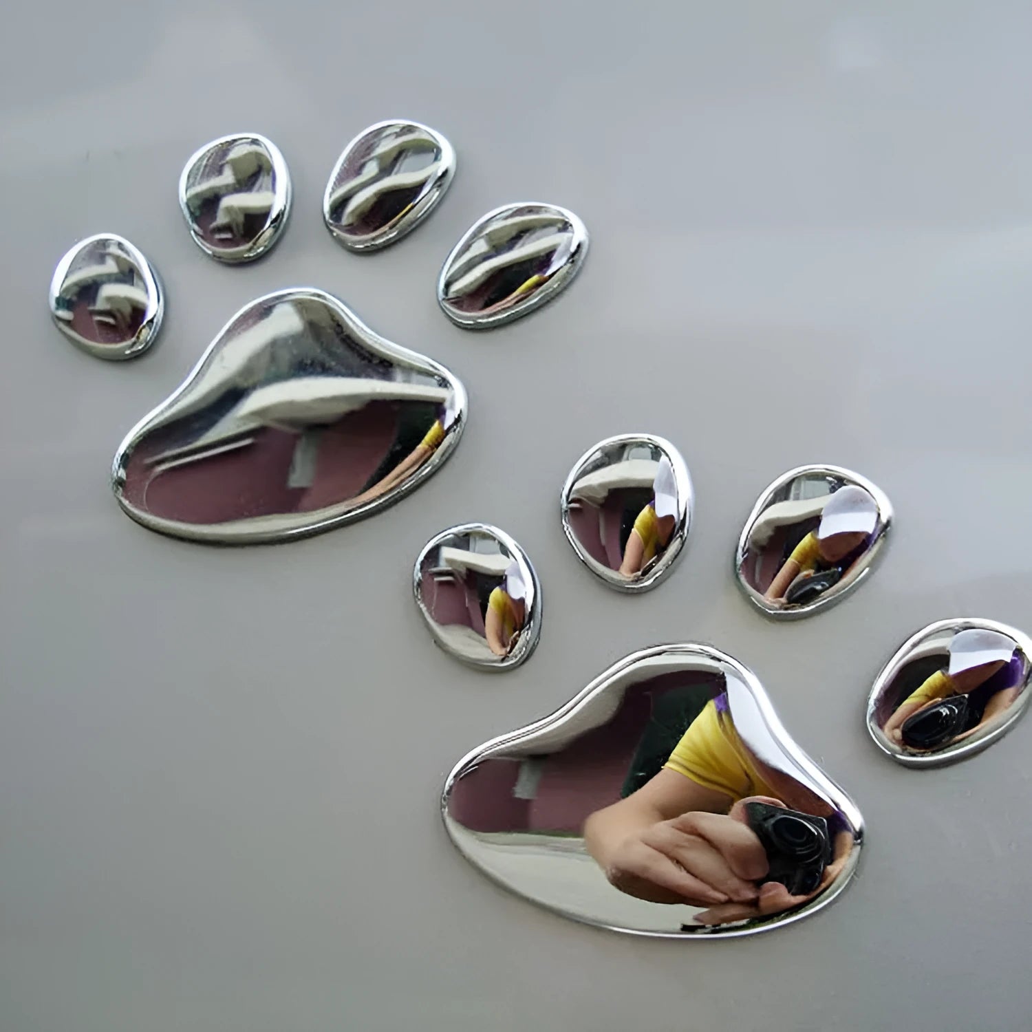 PVC car sticker shaped like a hand holding a brush, decorated with dog footprints pattern.