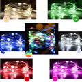 Flexible copper wire LED string light coiled on a table, showing small bulbs and a dual-power control box.