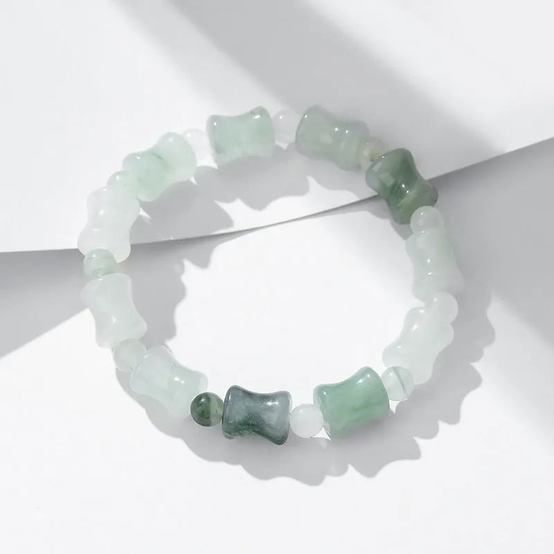 Simple beaded bracelet with a diamond-cut Tianshan Emerald chalcedony stone and coconut shell beads on an elastic band.