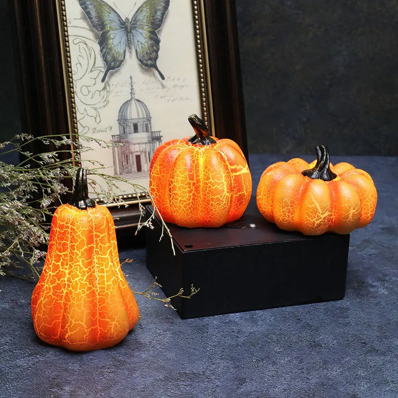 Three LED pumpkin lanterns in different sizes with realistic surface cracks and candle-like glow