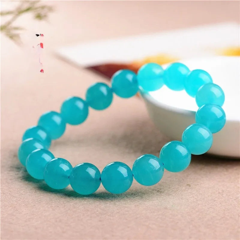 Polished natural Amazonite scattered beads in blue-green tones, shown loose and on a bracelet cord.