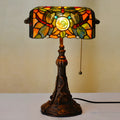 Tiffany-style desk lamp with a coloured stained glass shade on a resin base.