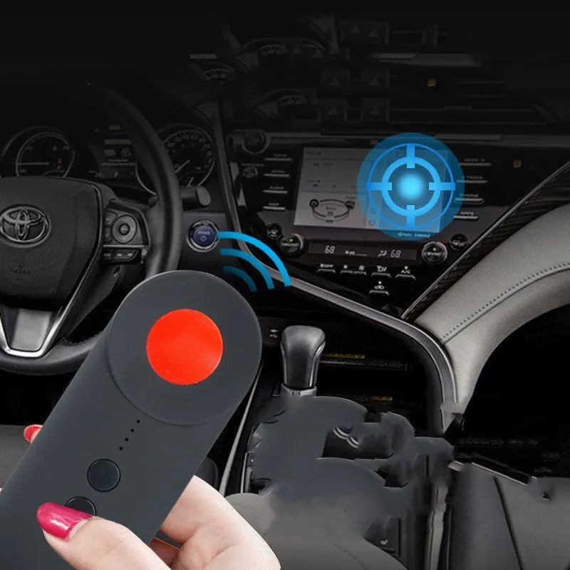 Black portable anti-car GPS and wifi signal detector with a USB cable on a table.