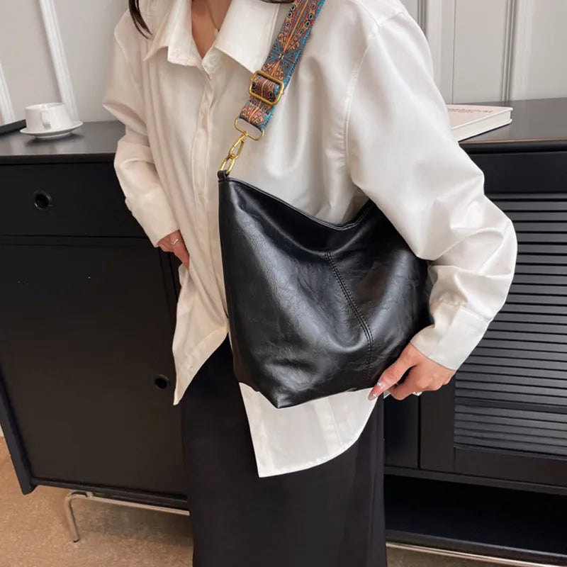 Retro bucket bag with wide shoulder strap, solid colour in beige, shown from front angle