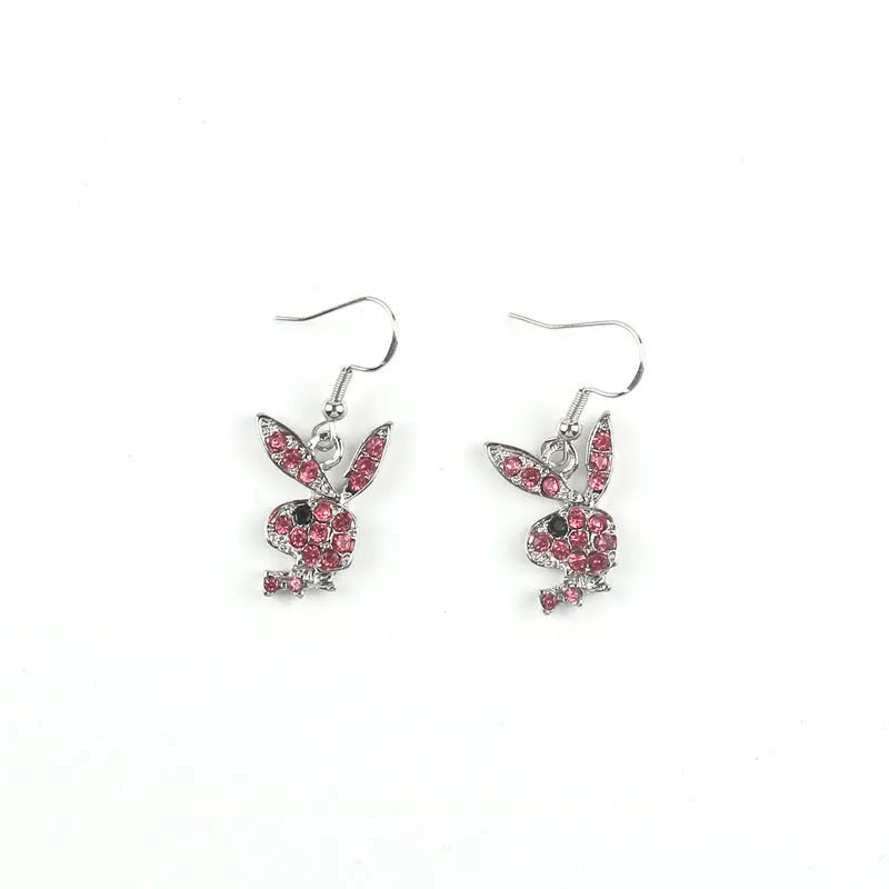 Close-up of a pair of cute rabbit-shaped stud earrings with sparkling cubic zirconia stones on a silver-coloured background.