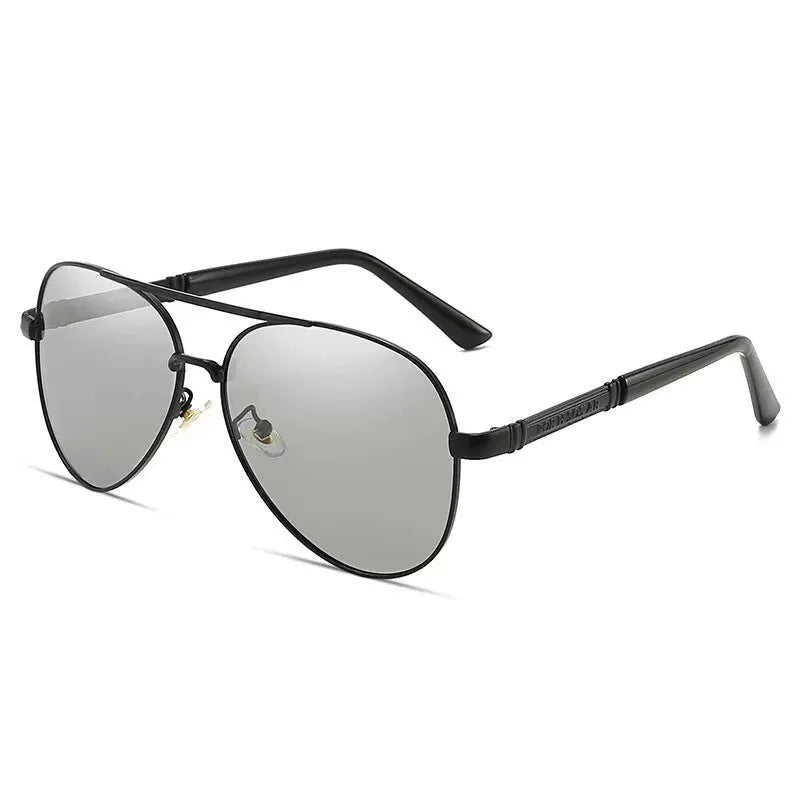Men's gold metal frame polarised sunglasses with dragon and phoenix decoration and grey lenses on a table.