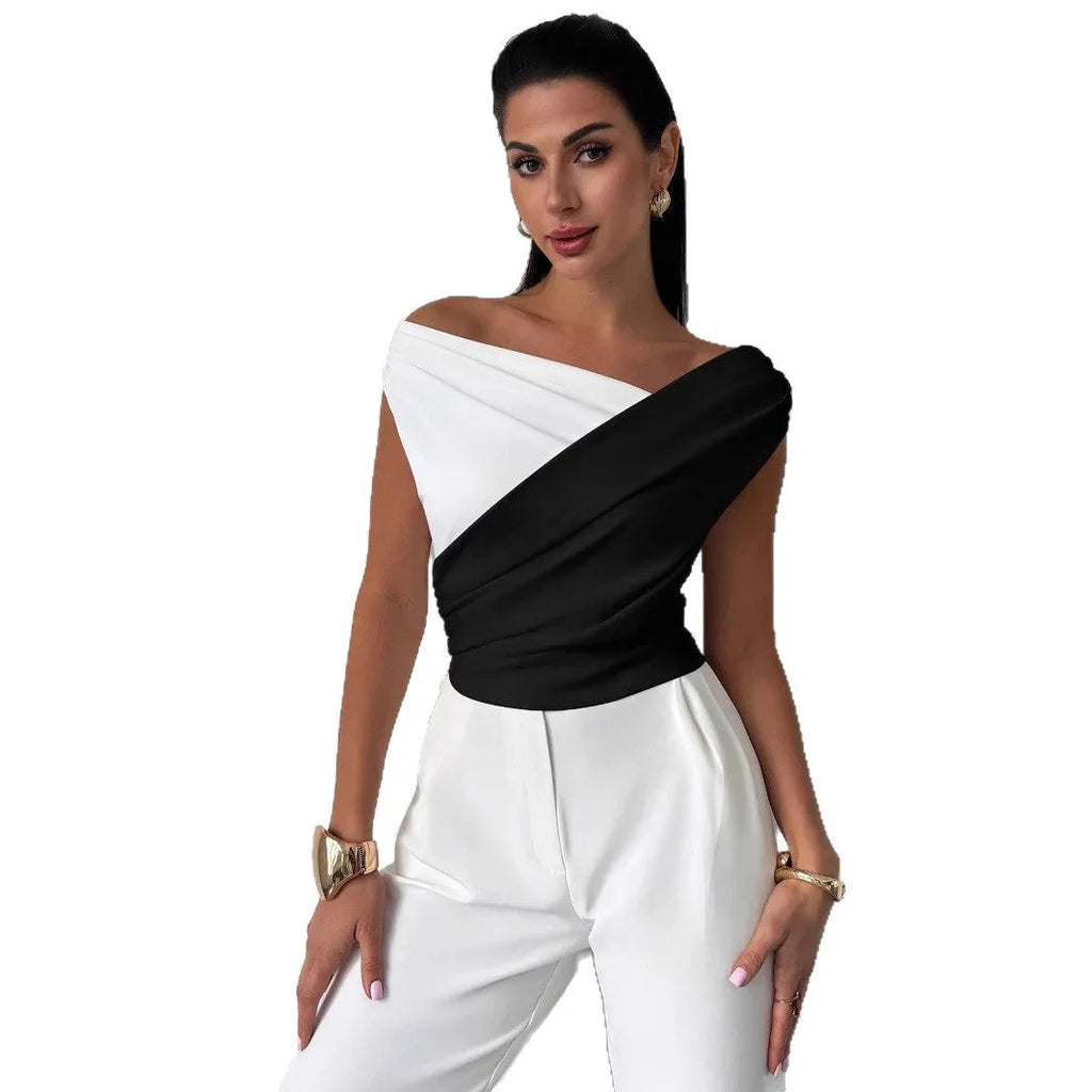 Color-blocked women's top with asymmetric shoulder and ruffled hem, slim fit, black with white panels, polyester fabric.
