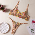 Floral patterned mesh bra with steel ring on T-back strap, shown in skin colour.