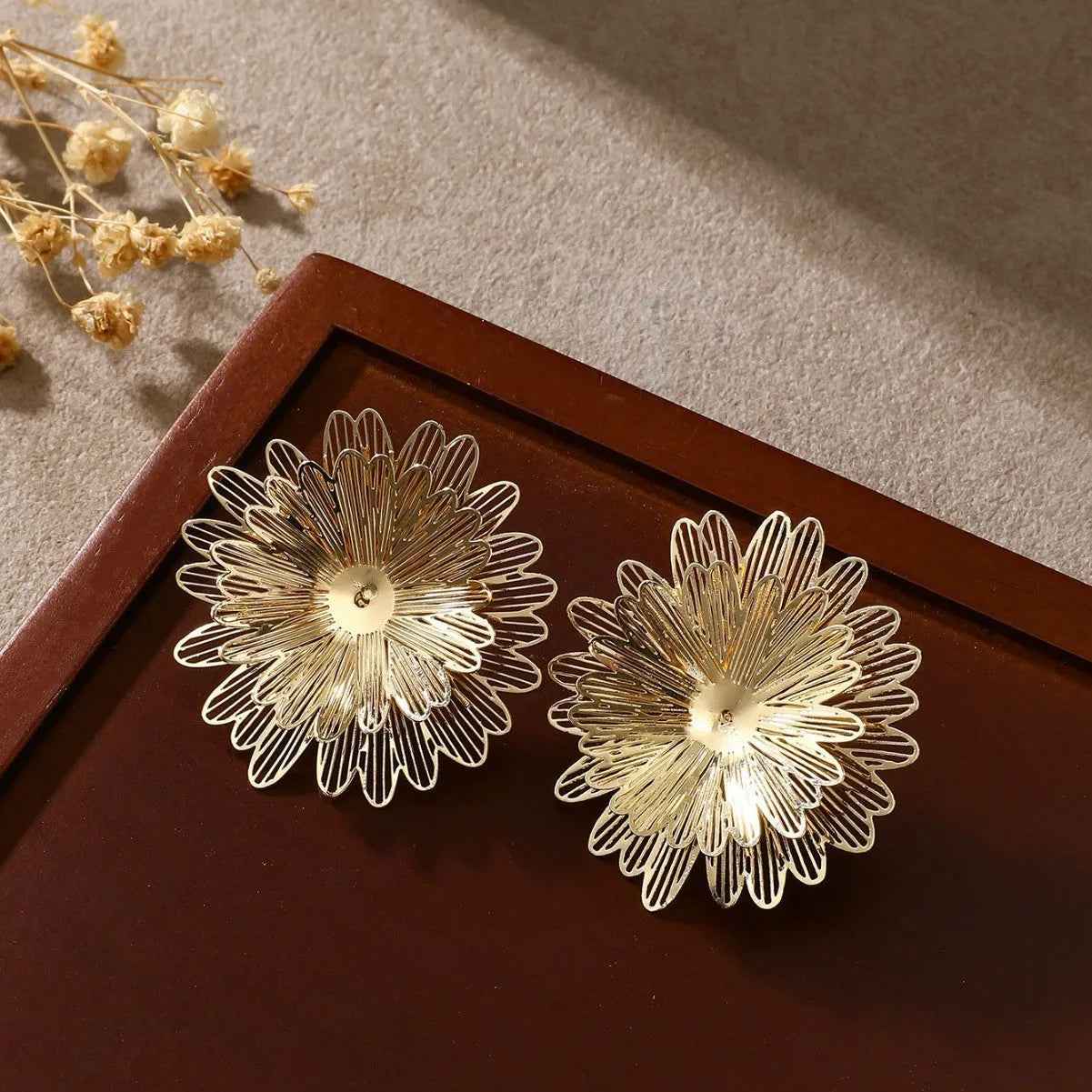 Three-dimensional hollow flower earrings in gold and silver alloy with daisy petals and electroplated finish