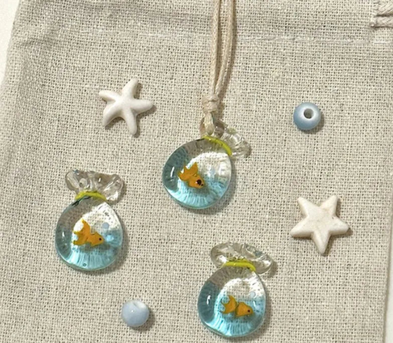 Women's coloured glaze pendant necklace on a braided cotton and linen clavicle chain, showing artisan finish.