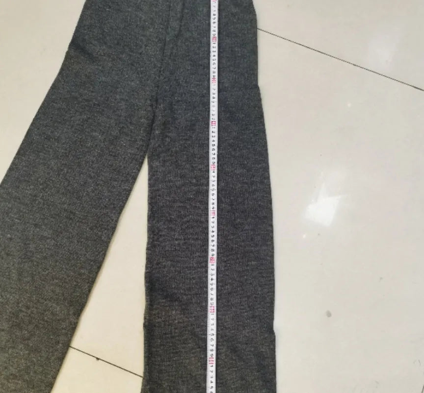 Women's dark grey acrylic knit co-ord set with side-slit sweater and matching trousers laid flat.