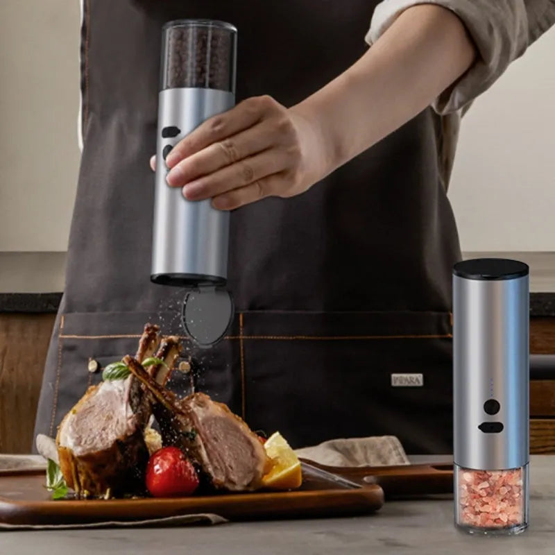 White electric salt and pepper grinder set with clear glass jar and stainless steel top on kitchen counter