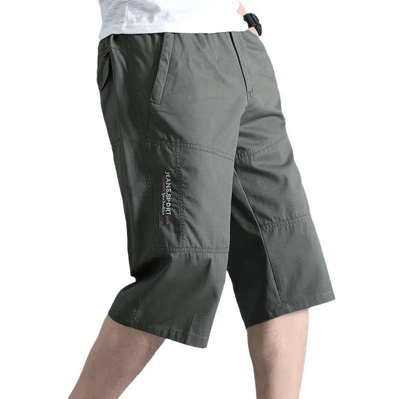 Men's loose-fit cotton sports trousers in cropped length, shown in army green colour.