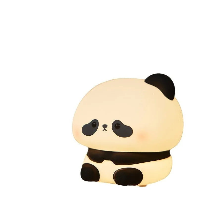 Cute panda LED night light with soft silicone cover, USB rechargeable, featuring colourful lighting modes on a bedside table.