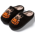 Black plush Halloween slippers with pumpkin print and a thick, textured TPR rubber sole.