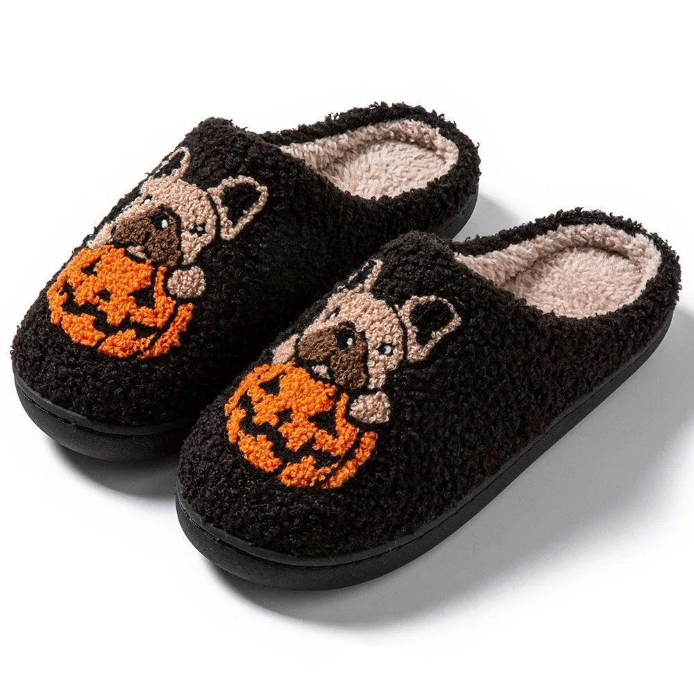 Black plush Halloween slippers with pumpkin print and a thick, textured TPR rubber sole.