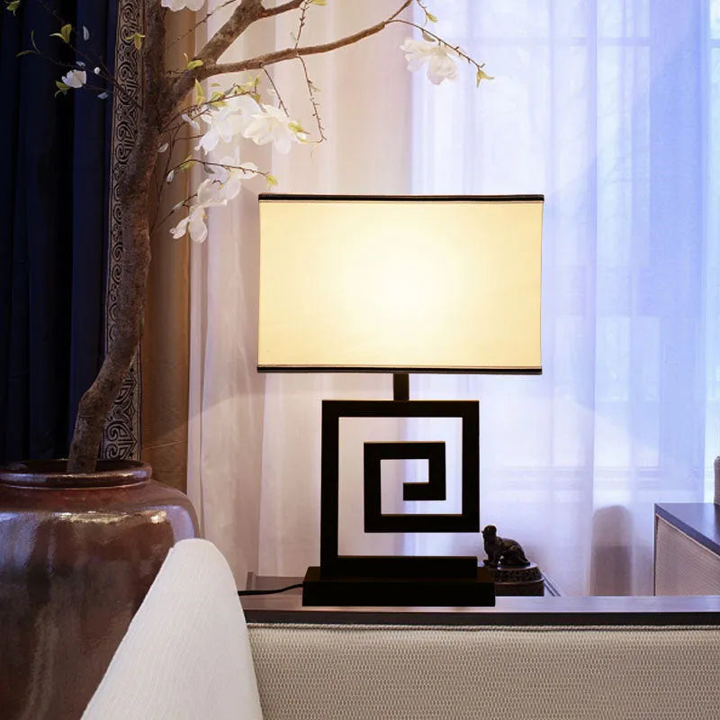 Retro style table lamp with fabric lampshade, iron frame, and remote control switch on a bedside table
