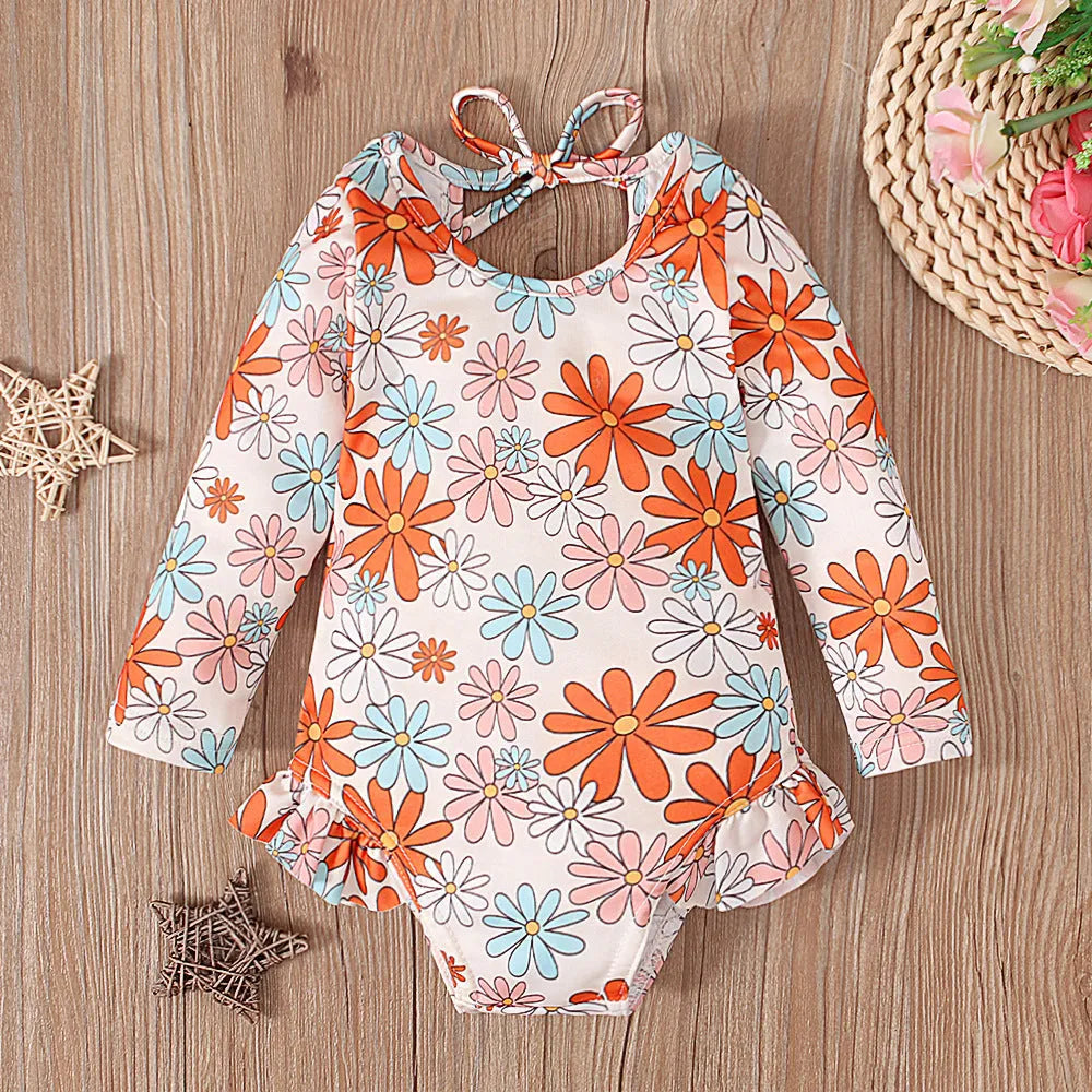 Girl's floral print open back swimsuit in orange, showing crew neck and briefs style.