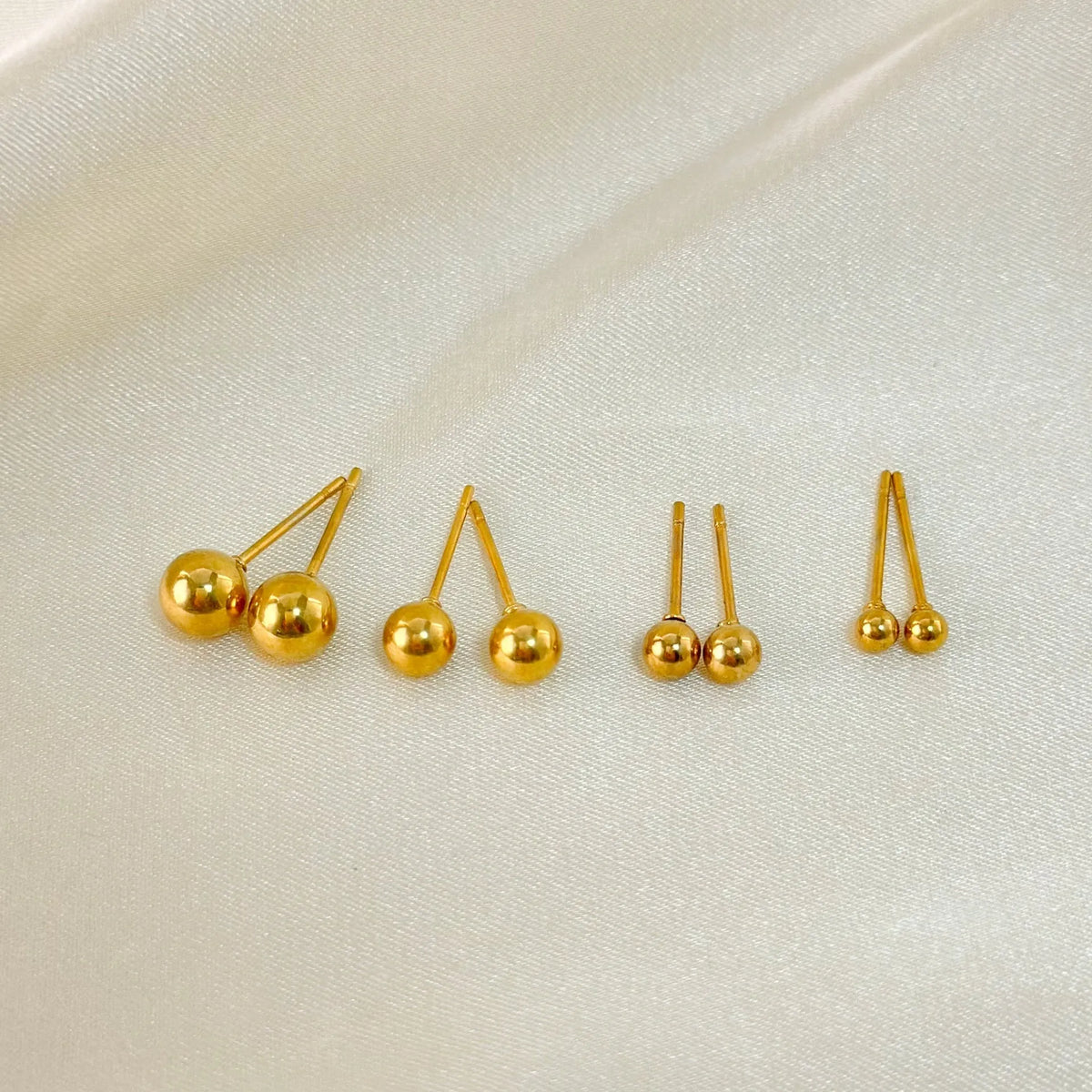 Round titanium steel ball stud earrings in 3mm to 6mm sizes with electroplated finish and simple geometric design.