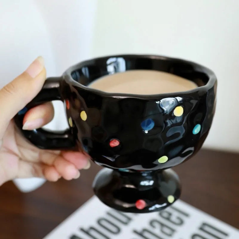 Hand-pinched irregular shaped solid colour ceramic mug on a table.