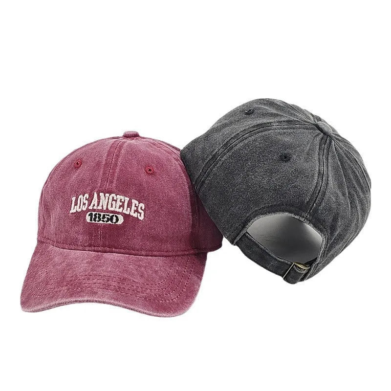 Retro distressed beige cap with adjustable strap and embroidered letters on a conical crown.